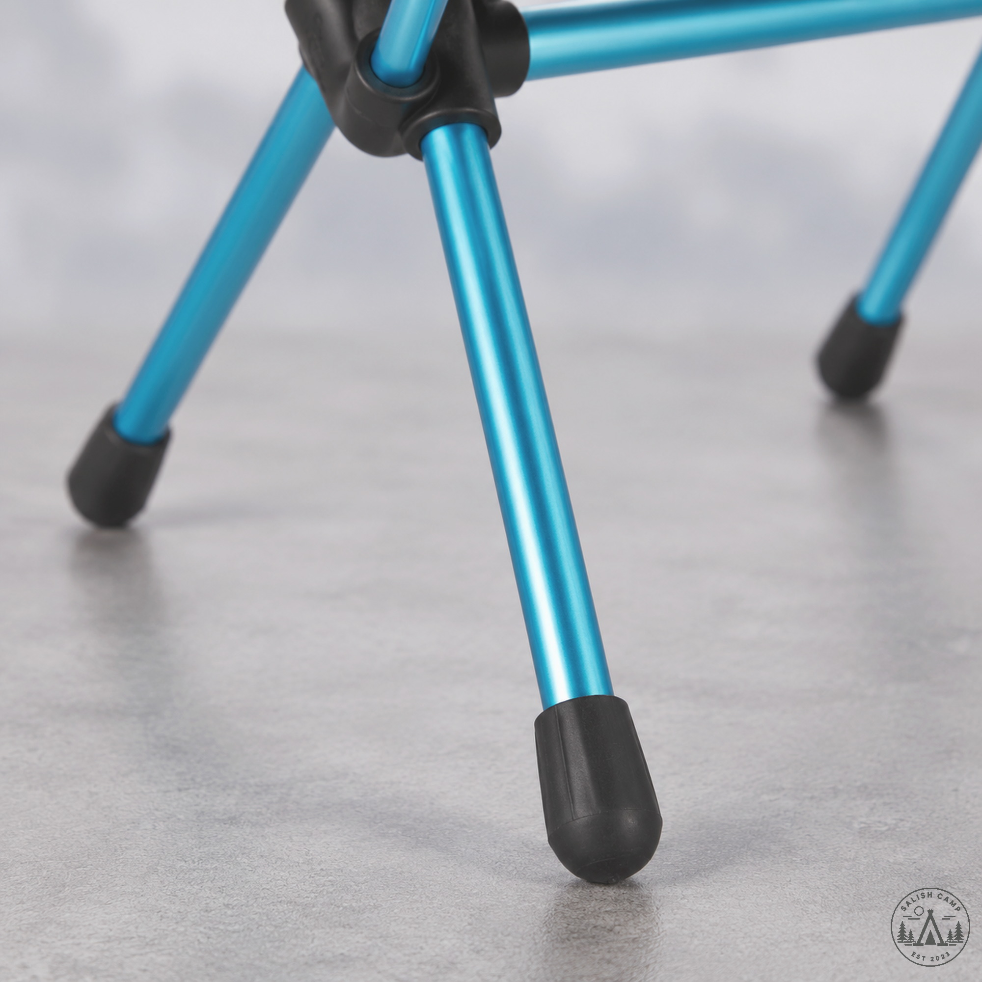 Helinox Chair Zero plain black rubber foot with cyan DAC pole on forest ground