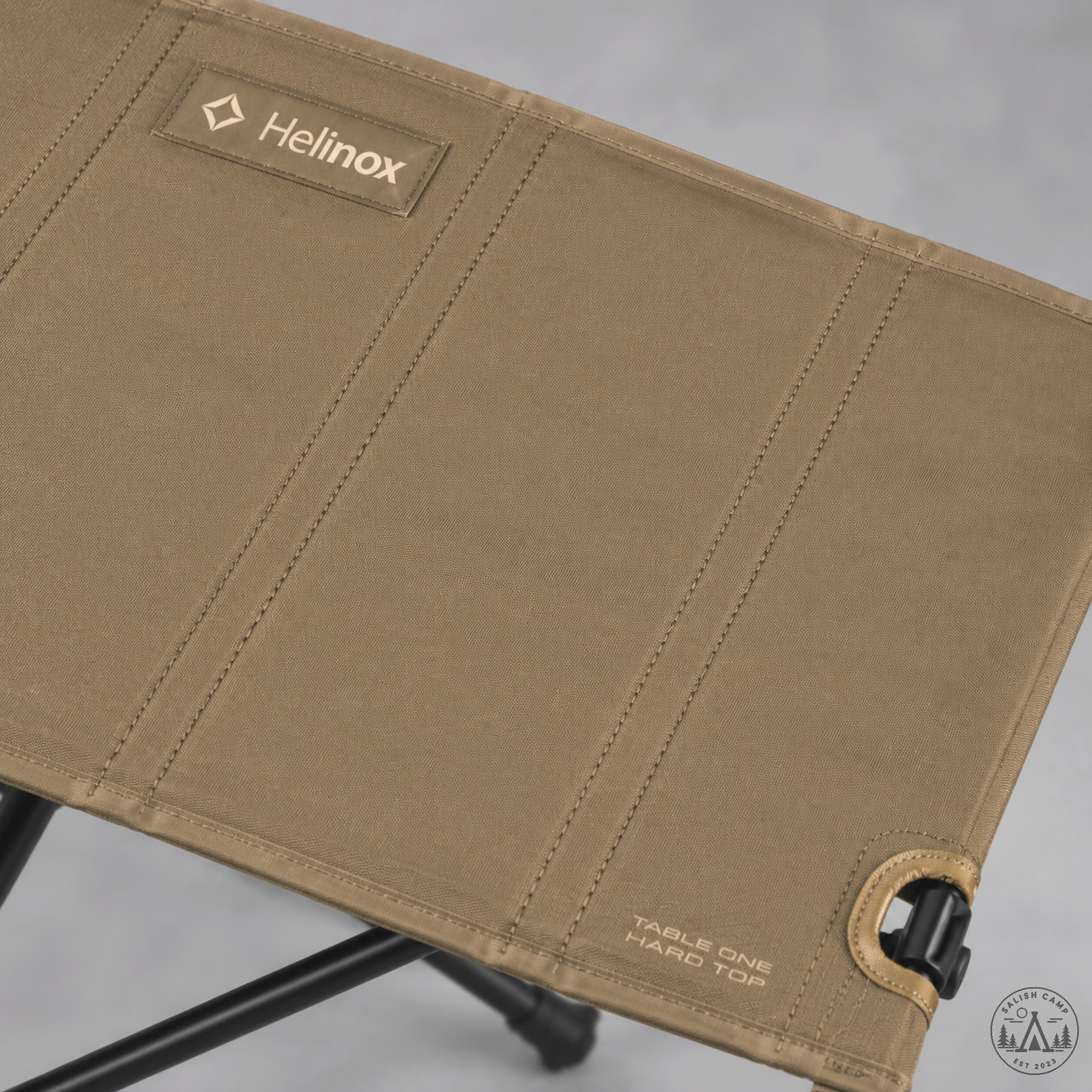Helinox Table One Hard Top Coyote Tan polycarbonate-reinforced surface close-up with Helinox patch