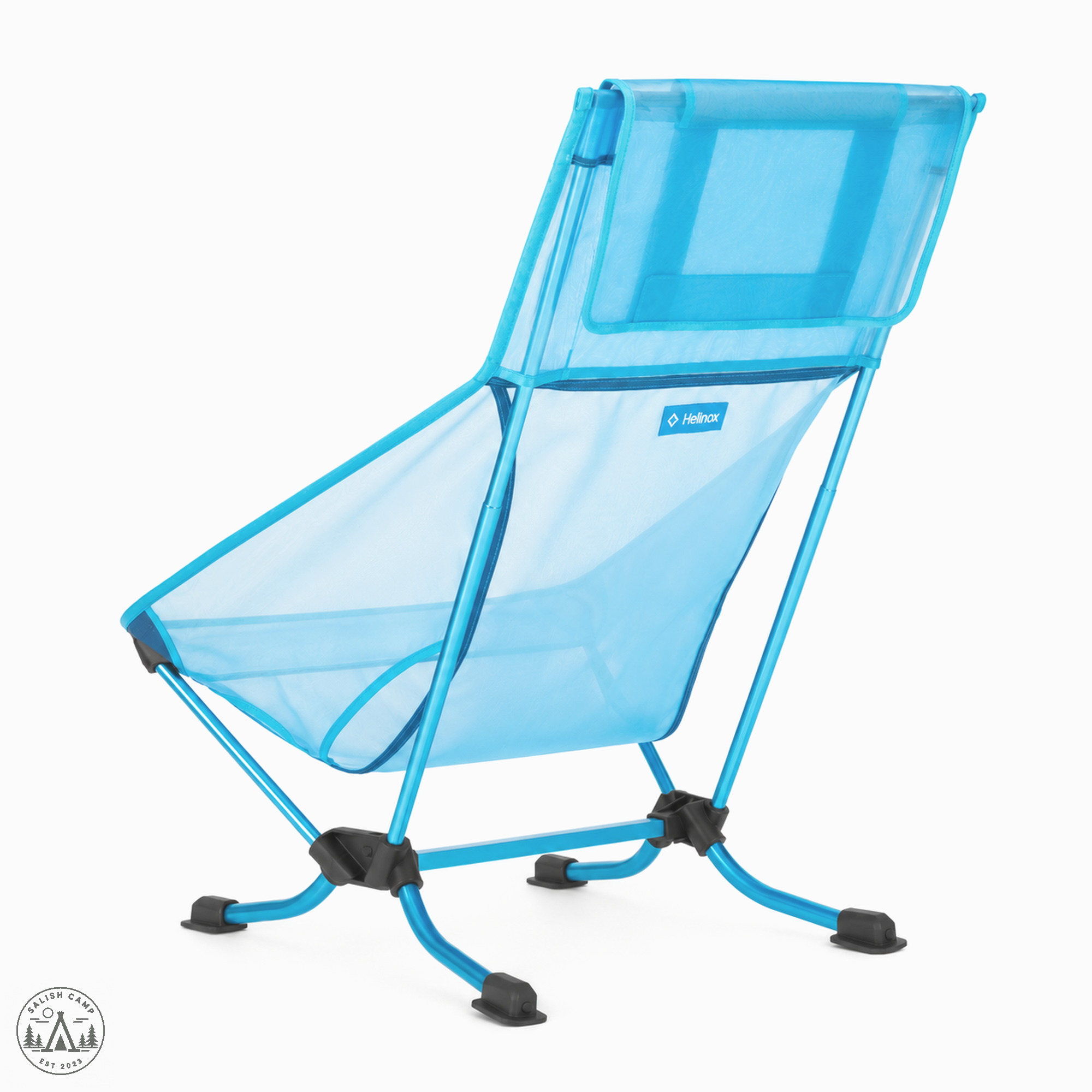 Back three-quarter view of the Helinox Beach Chair (re) in Blue Mesh, with cyan splayed legs and flat black feet