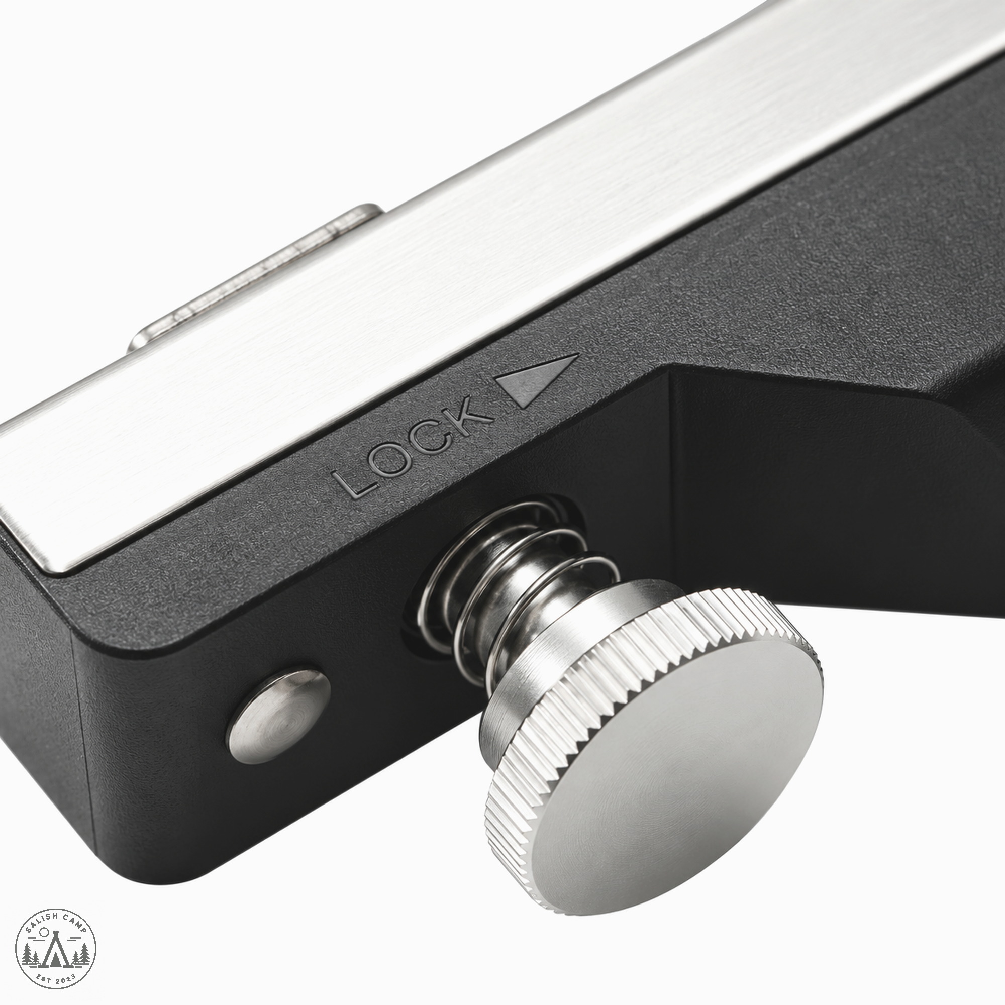 Knurled knob and coil spring on a black housing with the word LOCK beside a triangle