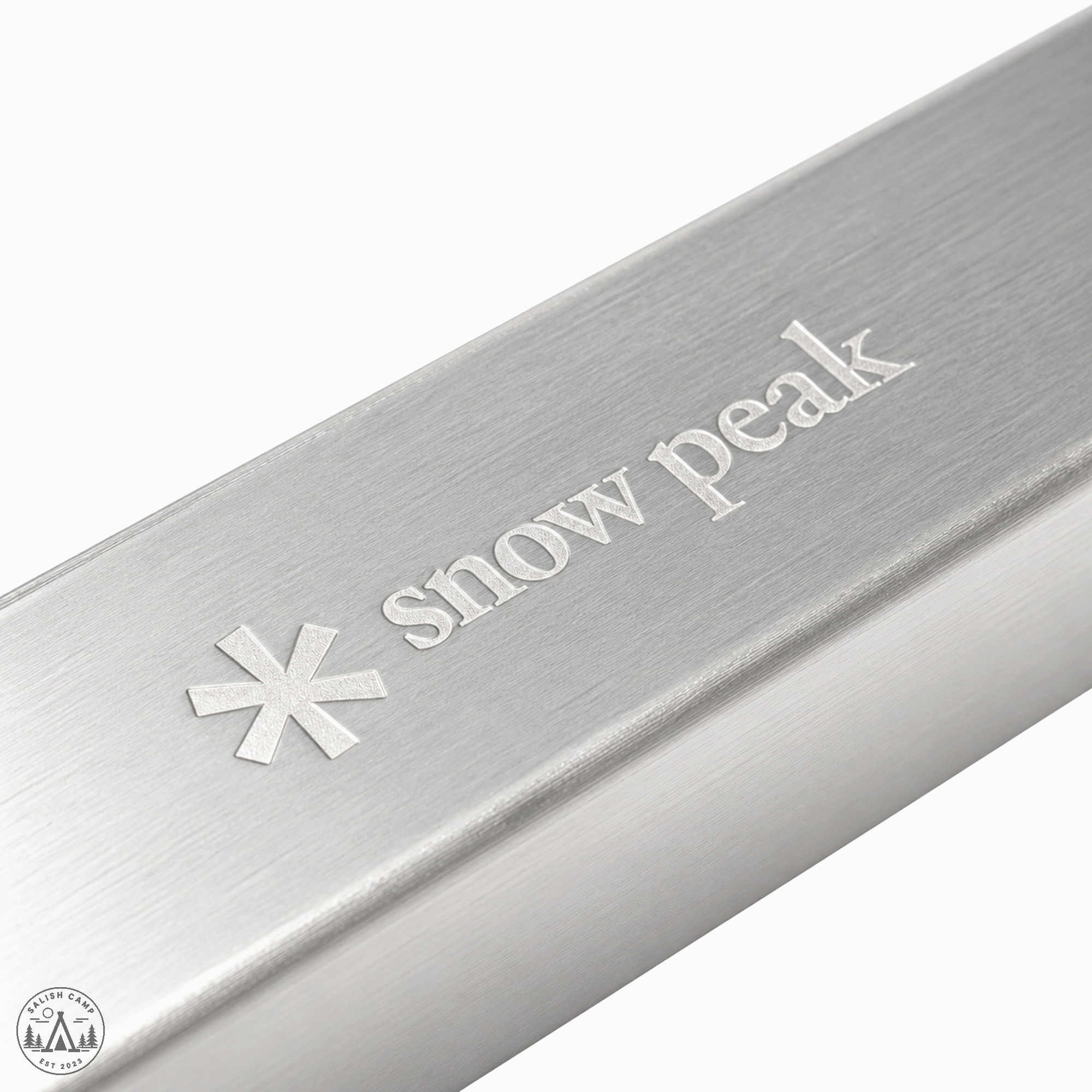 Brushed silver bar with an asterisk and the words snow peak