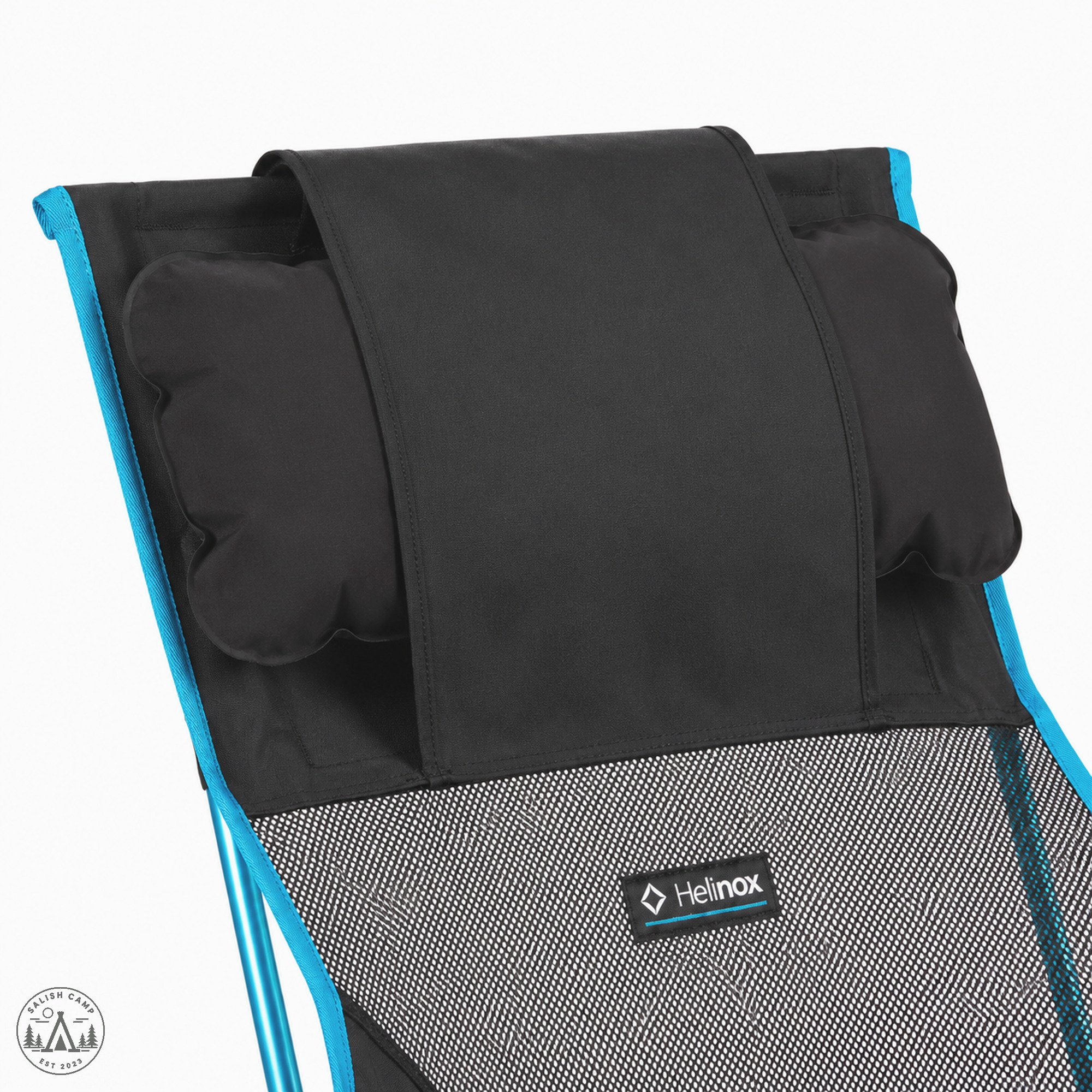 Close-up of the top of the Black Helinox Savanna Chair, with a black pillow tucked under the headrest flap