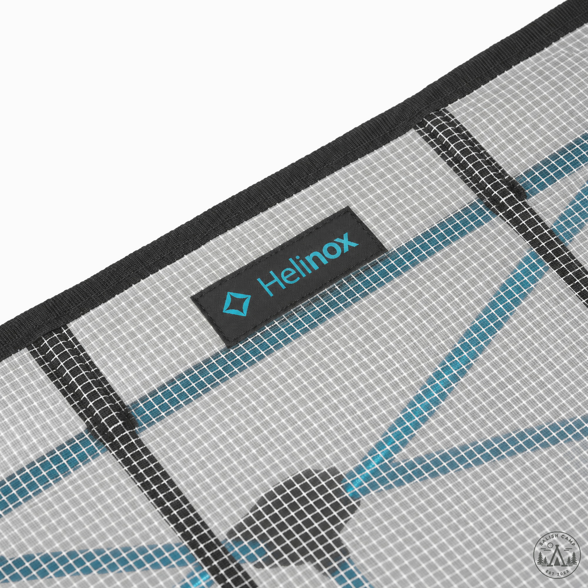 Close-up of the gray GhostGrid mesh tabletop with black binding and the Helinox tab
