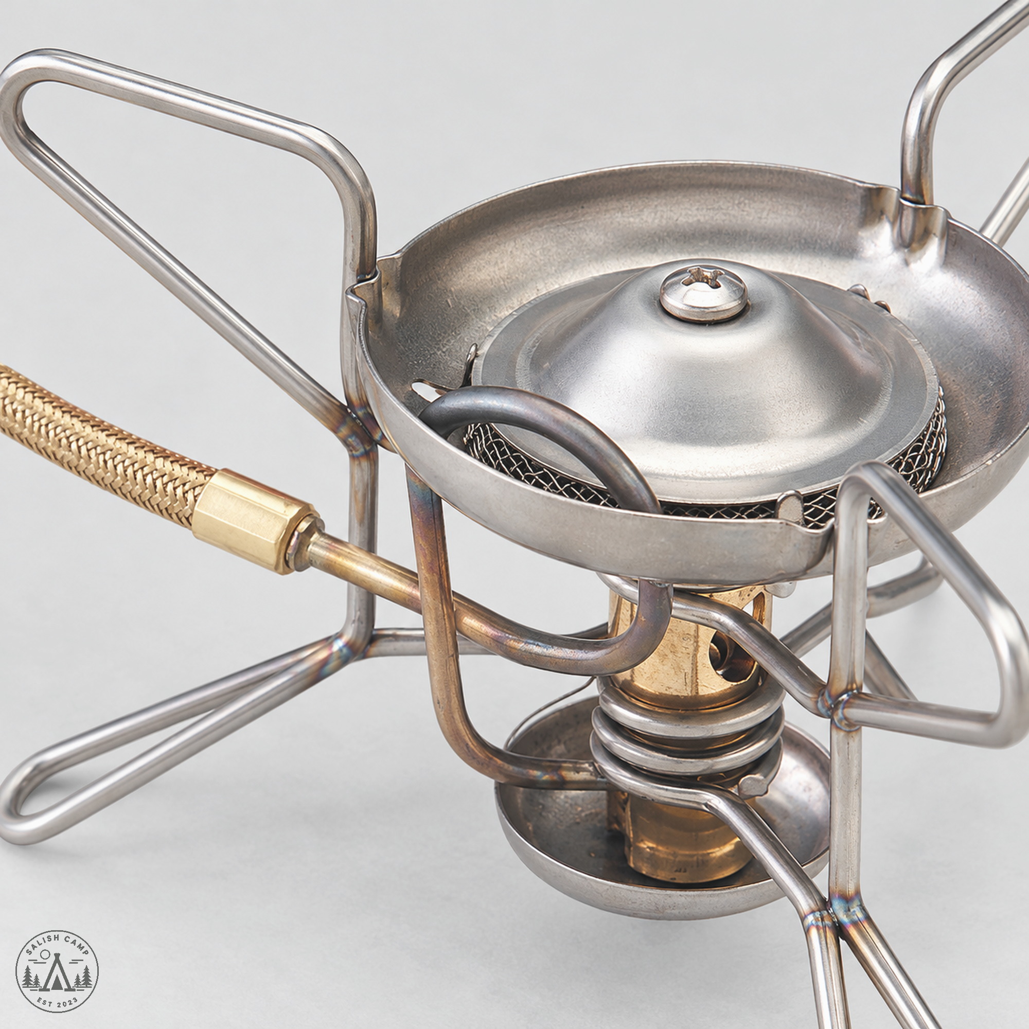 MSR WhisperLite brass burner and generator tube above stainless legs